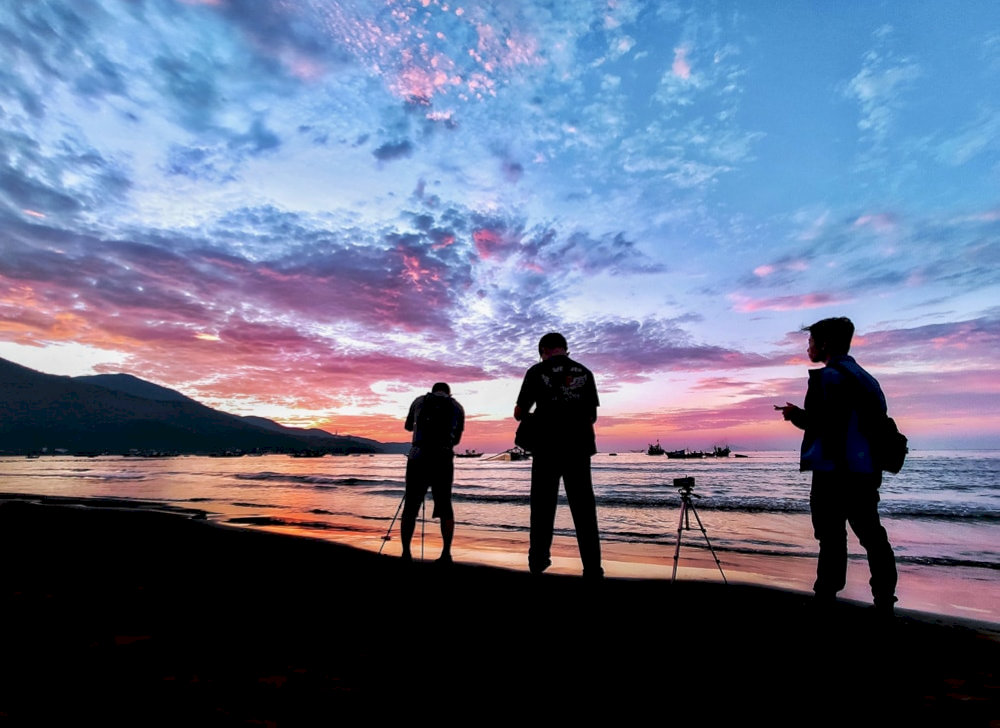My Khe Beach glows in golden light as the sky fades into pink, and purple at sunset